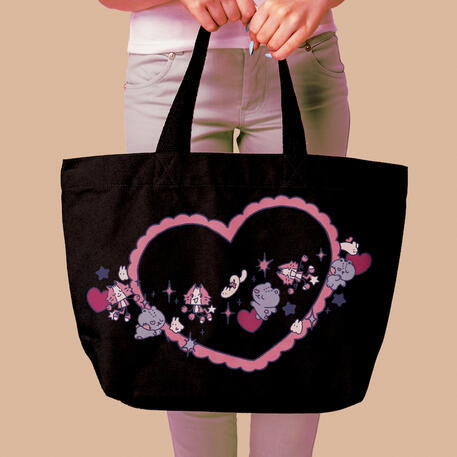 image of a black tote being held. the design on the bag is a heart with pink scallops outlining the shape. the two yuyuu mascots, the robot tiger and the stitched teddy bear, float across the heart like the ring of a planet. floating along with the mascots